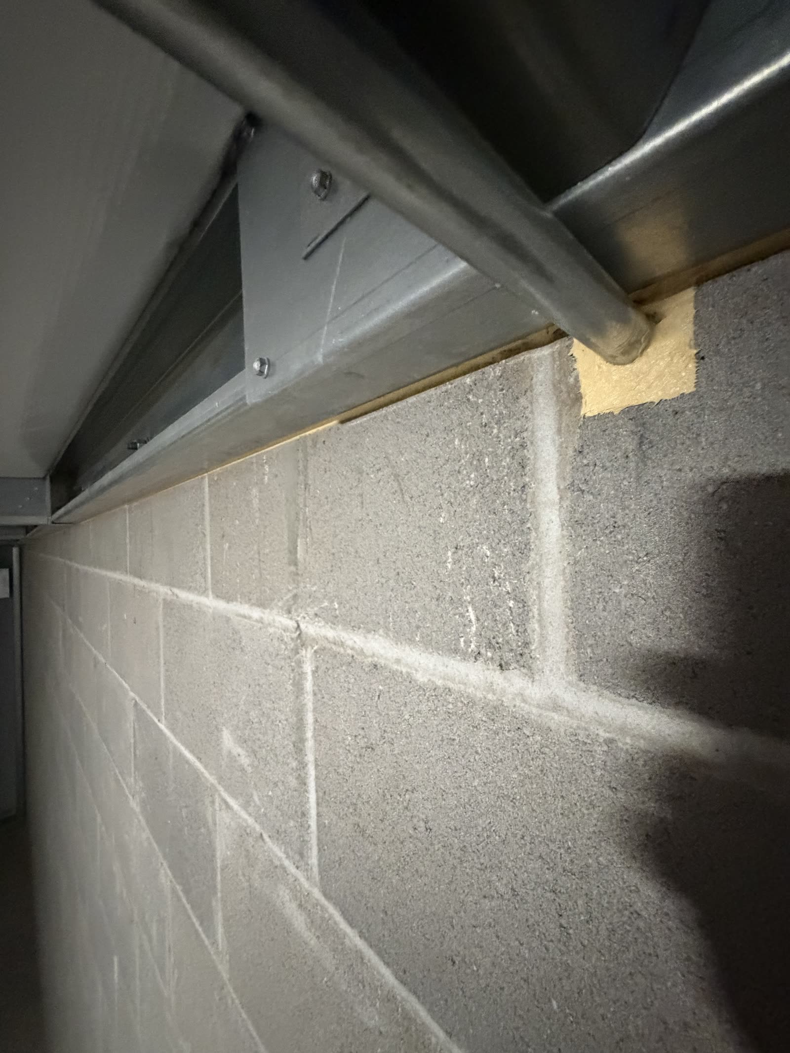 Pipe penetration through a CMU fire barrier wall sealed around the pipe with fire-rated caulk